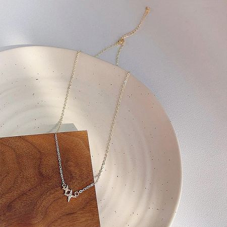 The double-star necklace elegantly displayed on a decorative surface.