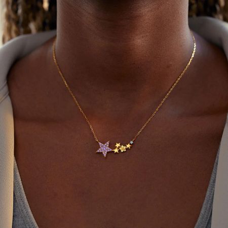 Elegant gold necklace featuring a mix of purple gemstone and solid gold star pendants.