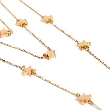 Close-up detail of the gold star charms on the layered necklace.