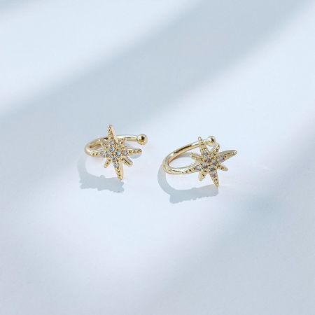 Front view of the gold starburst non-pierced ear cuff earrings.