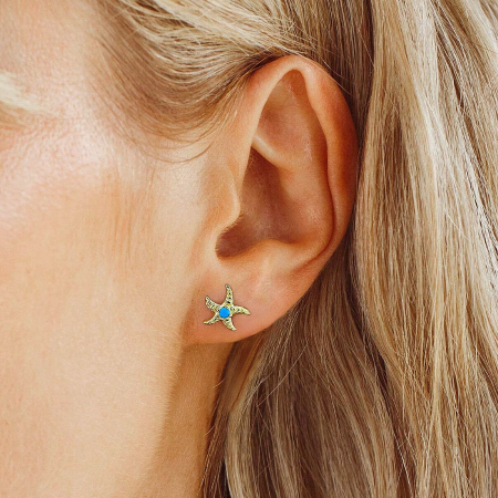 Model wearing the gold starfish earring, showcasing its size and appearance.