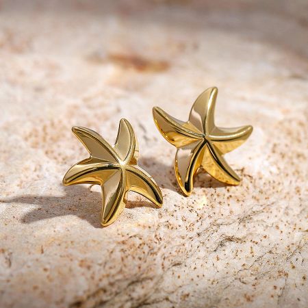 Close-up shot of the polished gold starfish stud earrings.
