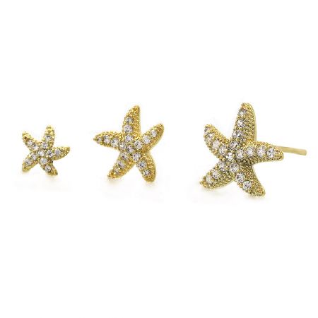 A close-up of the different sizes of the gold starfish earrings with clear gemstones.