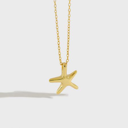 Detailed view of the gold starfish pendant on its delicate chain.