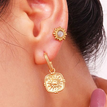 The radiant sun motif on the waterproof gold dangle earrings.
