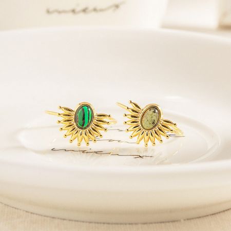 Matching sunburst earrings with green stones, part of the collection