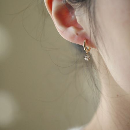 Close-up of a gold teardrop crystal earring from the zircon dangle hoop set.