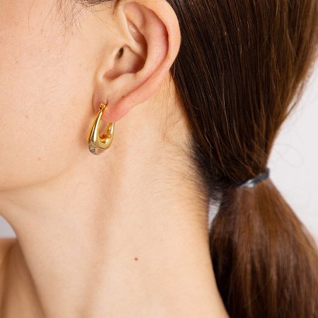 Close-up of a model wearing the gold U-shape hoop earring, showcasing its elegant fit.