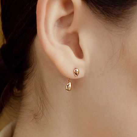 Detailed view of the gold drop shape earring, highlighting its unique two-wear design.