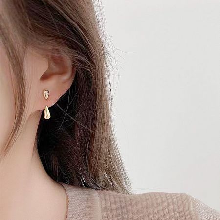 Model wearing the gold drop shape ear studs, showcasing their elegant look.