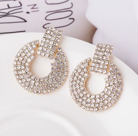 Alternative view of the statement earrings, showcasing a gold teardrop design with clear rhinestones.