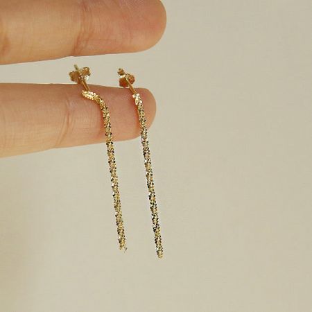 An alternative product shot of the pair of gold textured long earrings.