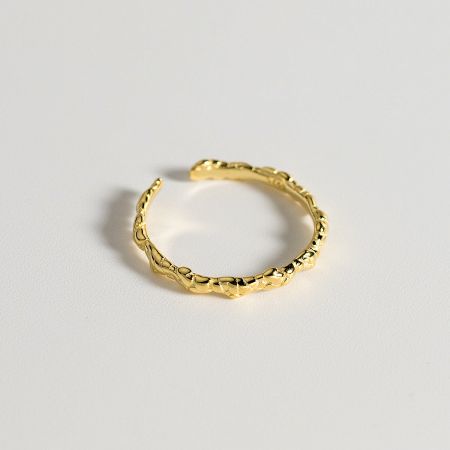 The adjustable open band of the gold braided ring, highlighting its unique design.