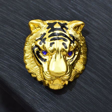 Angled view of the gold tiger head brooch, highlighting its polished finish.