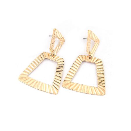 Close-up detail of the hollow, textured surface of the gold triangular geometric earrings.