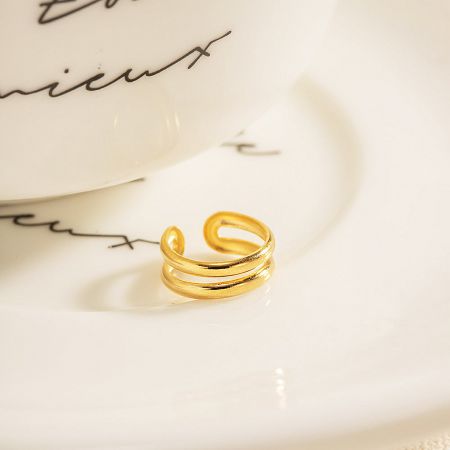 The double-layer ear cuff presented on a decorative white plate.