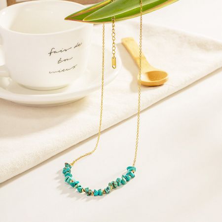 A stylishly arranged product shot of the gold and turquoise necklace, showing its elegant design.