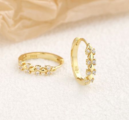 Detailed close-up of the gold flower hoop earring, highlighting the twisted design and the S925 sterling silver stamp.