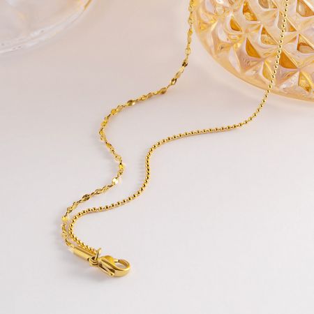 Detail of the gold twisted chain and secure clasp mechanism.