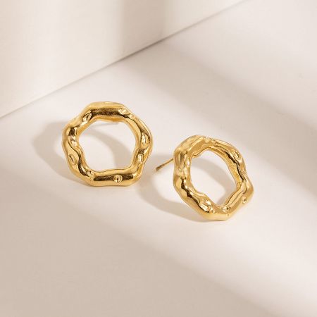 Close-up view of the hammered texture on the gold stud earrings.