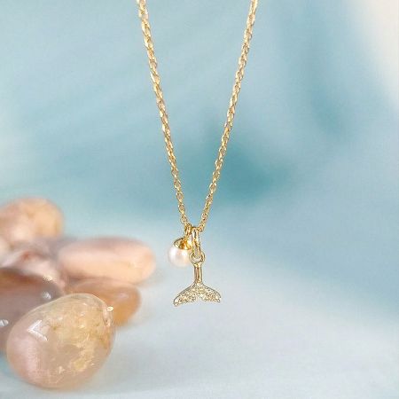 Wholesale 925 Sterling Silver Zircon Whale Tail with Pearl Necklace Set of 5 - A close-up of the 925 sterling silver zircon whale tail pendant necklace, showcasing the delicate pearl accent and sparkling crystals on the gold-colored chain.
