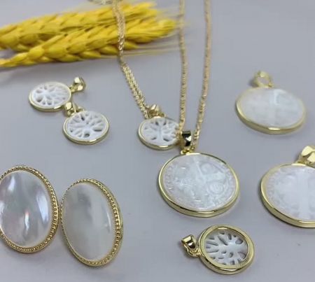A collection of custom religious jewelry pieces, showcasing various mother-of-pearl pendant designs and styles.