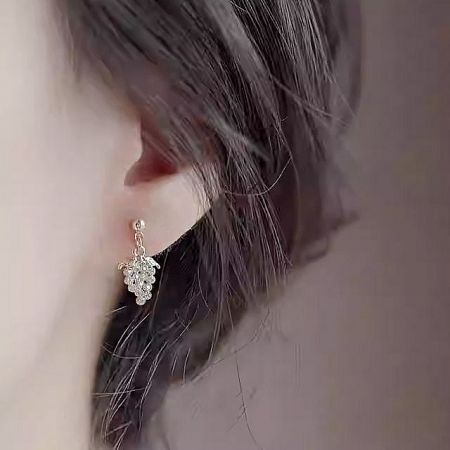 A close-up shot of a single grape-shaped dangling earring showcasing its intricate details.