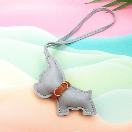 A sophisticated gray leather dog keychain with a brown strap and gold buckle.