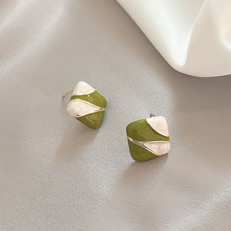 A pair of green and white earrings with gold accents on a neutral background.