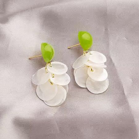 A pair of unique floral earrings with green and white elements on a gold-tone brass base.