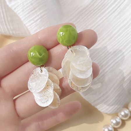 Another angle of the green bead and white disc earrings, highlighting their texture and shine.