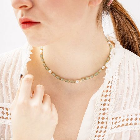 A delicate and minimalist green beaded necklace with pearls and gold details, perfect for layering.