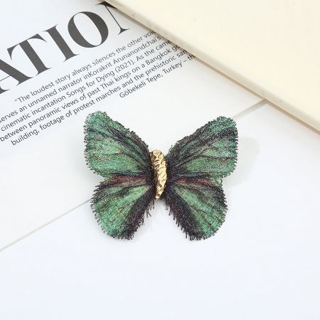 The emerald green gradient butterfly brooch, highlighting its unique handmade style.