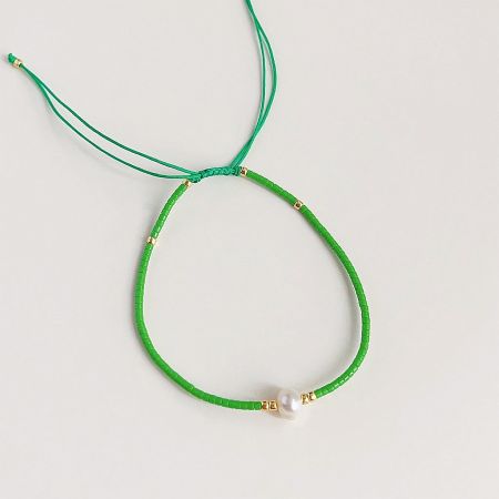 A delicate green cord bracelet featuring a single pearl and gold bead details.