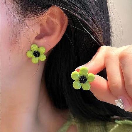 A pair of vibrant green daisy flower stud earrings on a plain background.