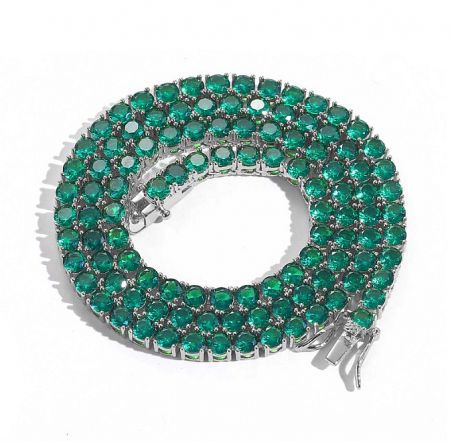 Custom hip hop jewelry style featuring a silver-toned bracelet with vibrant green gemstones.