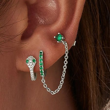 A close-up of the earring set featuring vibrant green and clear cubic zirconia gemstones on a white background.