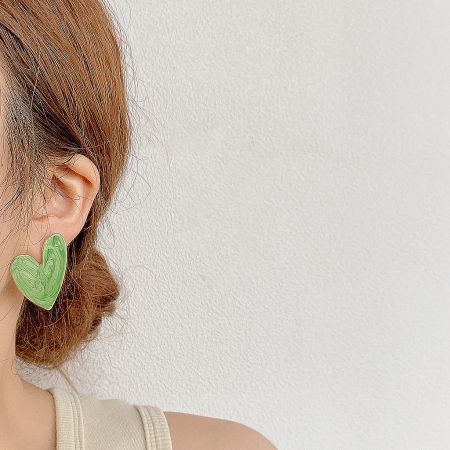 Model wearing a green vintage-style enamel heart-shaped stud earring.