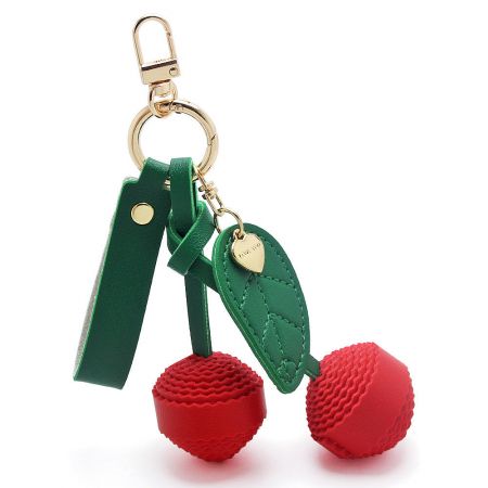 Detailed view of the vibrant red cherry keychain charm.