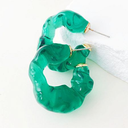 A pair of vibrant green ruffle C-shape stud earrings on a white surface.