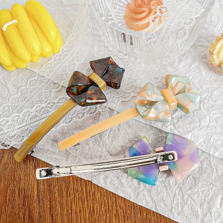 Acetate Bow Knot Barrette Hair Clips (Set of 5) - A collection of colorful acetate bow knot barrette hair clips, showcasing various designs and patterns available in the set.