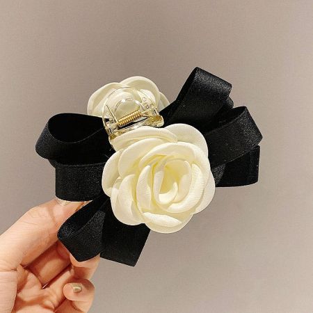 Front view of a single white camellia hair clip, highlighting the delicate flower and ribbon.