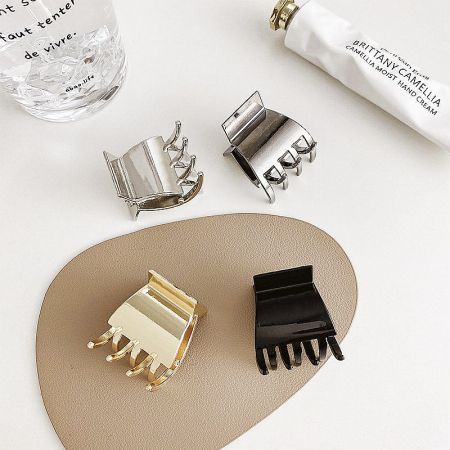 An arrangement of metal hair clips alongside beauty products, showcasing their versatility.