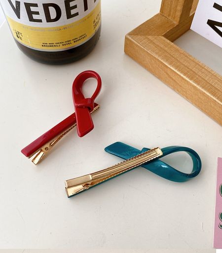 Close-up view of two stylish ribbon hair clips from the wholesale collection.