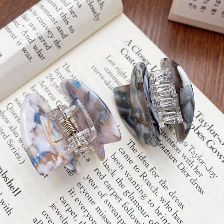 Two acetate hair clips with a beautiful marbled design, showing the claw mechanism.