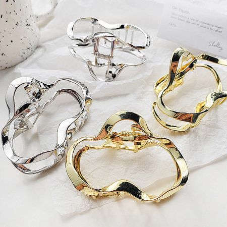 A collection of four metal wavy hair clips in both gold and silver.