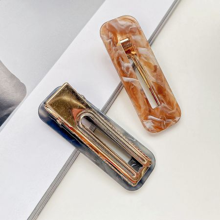 Two geometric square hollow hair clips, one in a light and one in a dark marbled pattern.