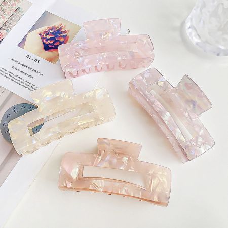 Four large acetate claw clips in blue, green, pink, and yellow, showcasing the color variety.