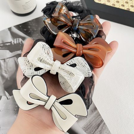 An assortment of hair scrunchies with acetate bow clips in multiple colors.