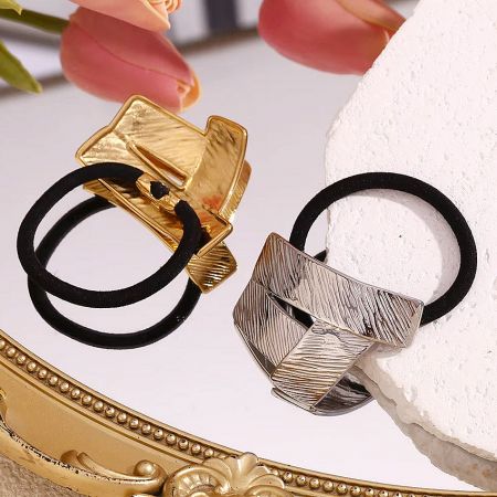 Angled view of the gold and silver geometric hair ties showing their textured metallic surface.